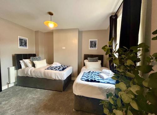 a hotel room with two beds and a plant at Sapphire Quarters, 3BR, En Suite, Private Parking in Hindlip