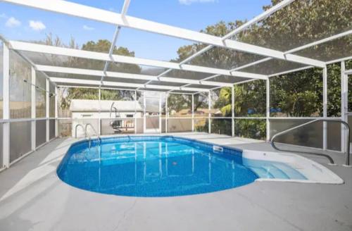 a swimming pool with a pergola on a patio at Little heaven in Spring Hill in Spring Hill