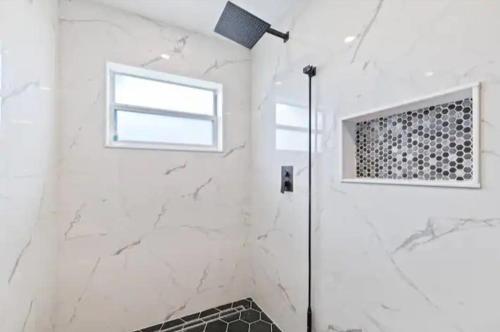 a white bathroom with a shower and a window at Little heaven in Spring Hill in Spring Hill