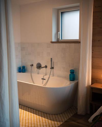 une baignoire dans une salle de bain avec une fenêtre dans l'établissement Chalets Hissala, vue lac et sauna, à Gérardmer