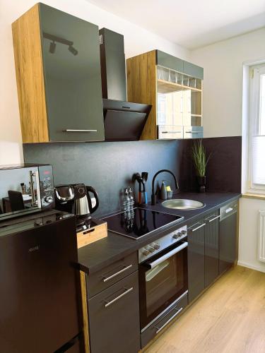 a kitchen with a black counter and a sink at 2 ZKB-3OG oder 3 ZKB-UG im Zentrum zw Rathaus und Dom in Augsburg