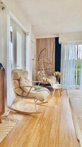 un salon avec une chaise et un canapé dans l'établissement Grande Maison Cosy à St Pierre Du Mont, à Saint-Pierre-du-Mont