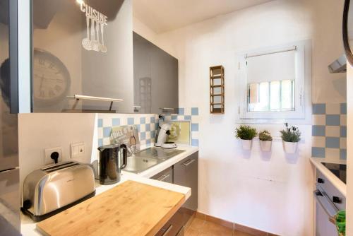 une cuisine avec une table et un comptoir dans l'établissement Résidence Hôtel du Golf de Pont Royal - maeva Home - Appartement climatisé 2 pièces 4 personnes - Prestige - super Home MAE-8801, à Mallemort