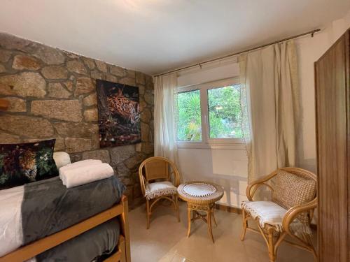 ein Schlafzimmer mit einem Bett und zwei Stühlen und einem Fenster in der Unterkunft AfriKana in Arenas de San Pedro