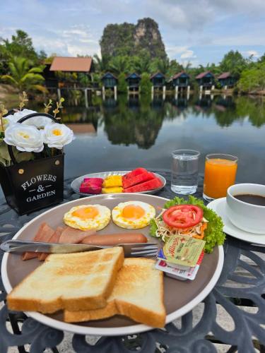 a plate of food with eggs and toast on a table at Baannai Lake View Resort in Ao Nang Beach
