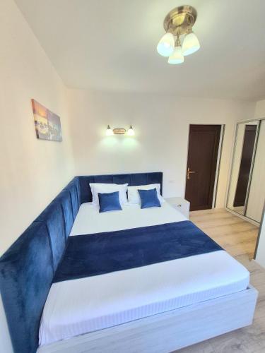 a bedroom with a large blue bed with blue pillows at Vila Kos in Mamaia Nord