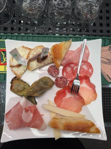 a plate of food with a fork and different meats at Affittacamere Il Tiro a Segno in Norcia