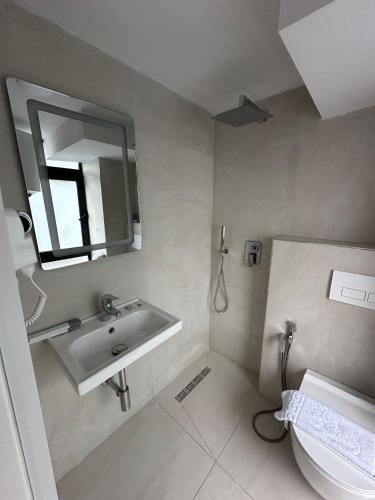 a bathroom with a sink and a toilet and a mirror at Bel Ami Tirana 2 in Tirana