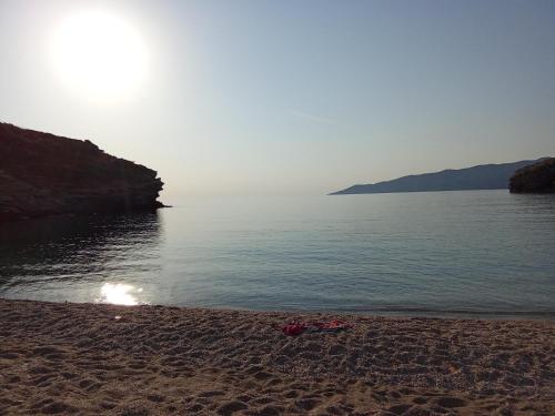 a sandy beach with the sun rising over the water at Vitali sea house III in Vitálion