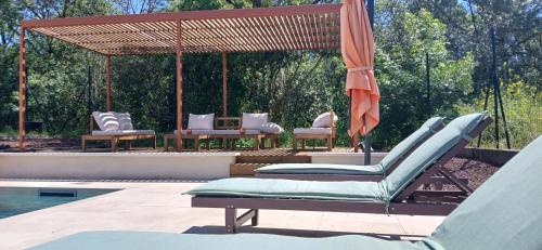 - un groupe de chaises et un parasol à côté de la piscine dans l'établissement Villa st Francois Piscine privée chauffée ,clim ,parking gratuit, à Carcassonne