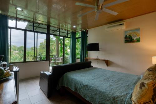 a bedroom with a bed and a large window at Boutique Hotel Las Cascadas in Manuel Antonio