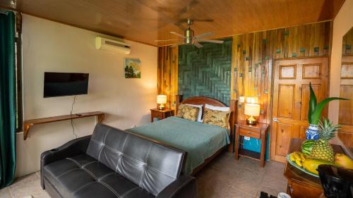 a bedroom with a bed and a couch at Boutique Hotel Las Cascadas in Manuel Antonio