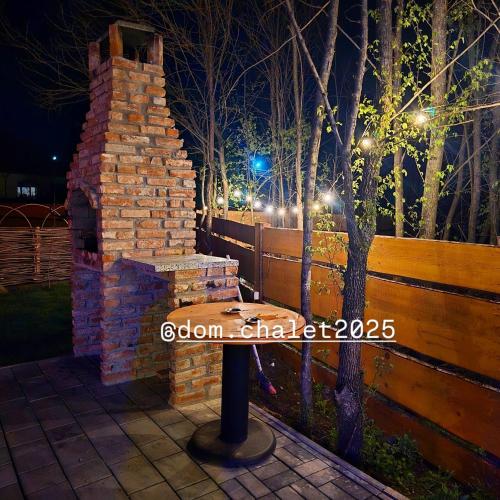 a brick fireplace on a patio at night at Dom Chalet in Tisău