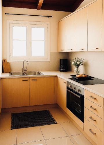 a kitchen with white cabinets and a sink at Riviera in Agios Nikolaos