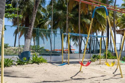 an empty playground withswingocles and palm trees at Mi estadía in San Juan