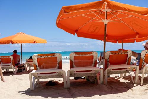 a group of chairs and umbrellas on a beach at Mi estadía in San Juan