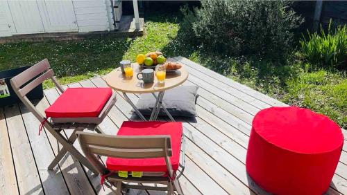 - une table et des chaises avec un bol de fruits sur la terrasse dans l'établissement La Coccinelle, à Gujan-Mestras