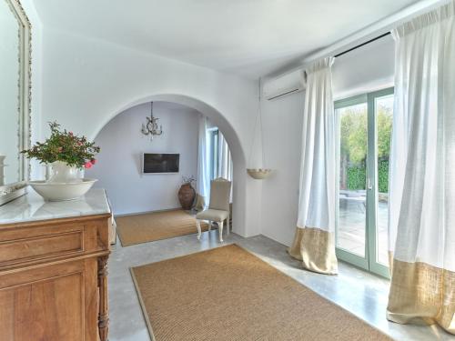 a living room with white walls and a large window at Villa Joy with private pool, close to Naoussa in Kóstos