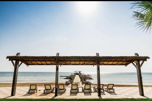 eine Gruppe von Stühlen unter einem Pavillon am Strand in der Unterkunft Thalassa Beach Resort - 108 in Vokolidha