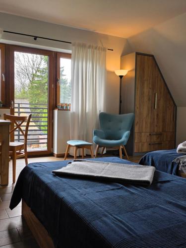 a bedroom with a bed and a chair and a window at U Suchowiana - cisza i spokój z widokiem na Tatry in Zakopane