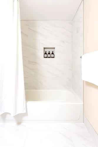 a white bathroom with a tub and a shower curtain at Downtown Hartford Condo - Ciy Center - Prime Location in Hartford