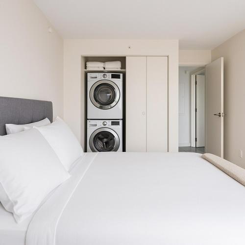 a white bed with a washing machine in a room at Downtown Hartford Condo - Ciy Center - Prime Location in Hartford