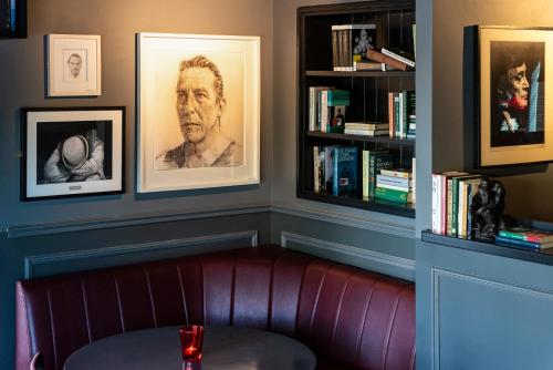 a red leather couch in a room with bookshelves at Cliffs of Moher Hotel in Liscannor