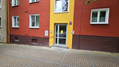 a yellow and red building with a door at Apartmán Sokolovská in Karlovy Vary