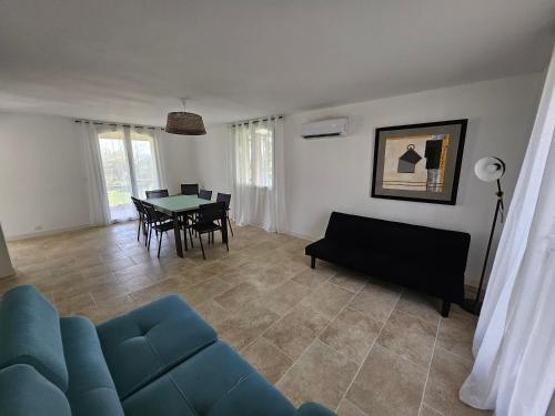 un salon avec un canapé bleu et une table dans l'établissement Le calme entre gorges du Verdon et Luberon, à Pierrevert