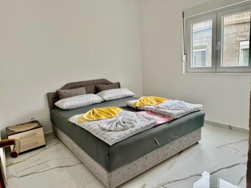 a bed with two pillows on it in a room at Apartmani Gusani in Radanovići
