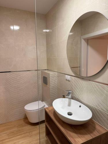 a bathroom with a sink and a toilet and a mirror at Sportowa 10 in Jastarnia