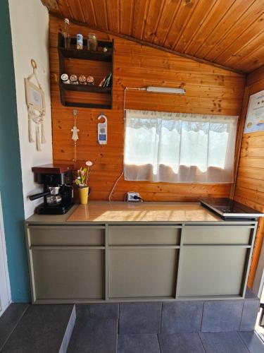 a kitchen with a counter top with a window at Zsonglak Vendégház in Kővágószőlős
