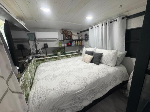a bedroom with a white bed in an rv at Unique Adventure Awaits in This Custom Tour Bus Conversion! in Clermont