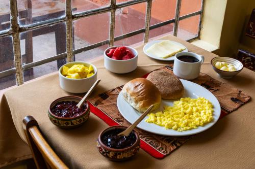 een tafel met daarop een bord met eten en roerei bij Eco Inn in Cuzco