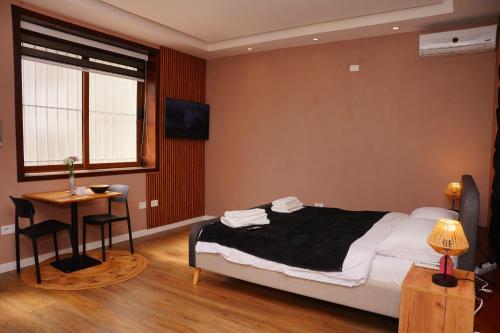 une chambre avec un lit, une table et une fenêtre dans l'établissement Cherry Rooms, à Tirana