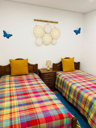 two beds sitting next to each other in a room at Burguesinha AL Entre-os-Rios in Entre-os-Rios