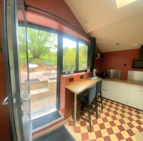 une cuisine avec une table et une grande fenêtre dans l'établissement Le Clos De Marissel - Terrasse et Jardin, à Beauvais
