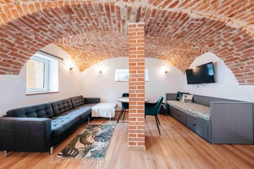 a living room with a couch and a brick ceiling at Penzion Pod Vinicemi in Litoměřice