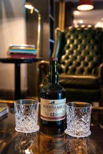 a bottle of wine and two glasses on a table at Cliffs of Moher Hotel in Liscannor