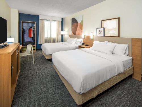 una camera d'albergo con due letti e una scrivania di Spark By Hilton Kannapolis a Kannapolis