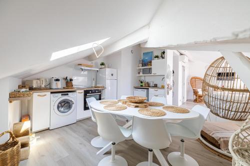 une cuisine et une salle à manger avec une table et des chaises blanches dans l'établissement WELCOME - Stunning 2-bedroom at 5 minutes from Palais des Festivals, à Cannes
