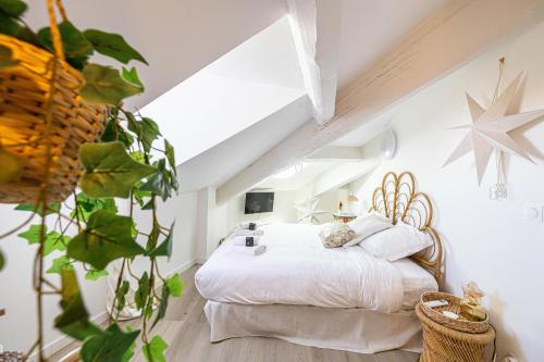 une chambre avec un lit blanc dans un grenier dans l'établissement WELCOME - Stunning 2-bedroom at 5 minutes from Palais des Festivals, à Cannes