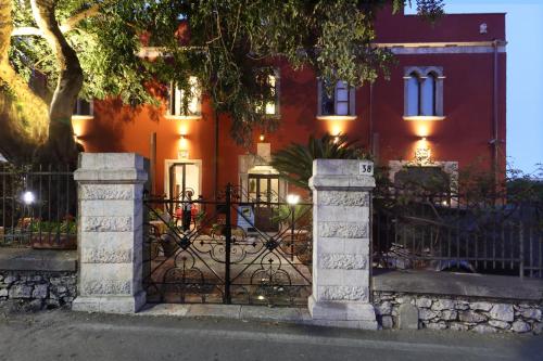 a wrought iron gate in front of a red house at Villa Astoria in Taormina