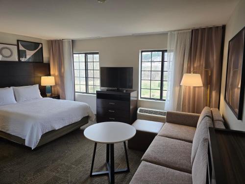 una habitación de hotel con una cama y un sofá en Staybridge Suites Colorado Springs North by IHG, en Colorado Springs