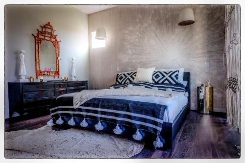 a bedroom with a bed and a dresser and a mirror at Luxury Living in West Hollywood Modern 3BR Home w Pool & Hot tub in Los Angeles