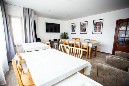 a living room with tables and chairs and a dining room at Pensiunea Nobila in Beclean
