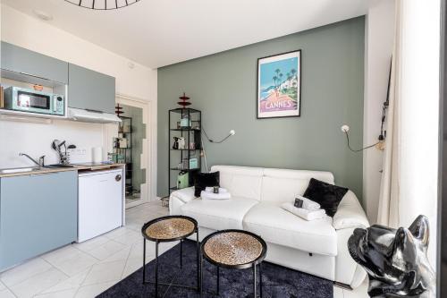 un salon avec un canapé blanc et une cuisine dans l'établissement PRIVATE - Small studio for two at 5 minutes from Croisette, à Cannes