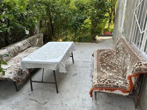 a table and a bench sitting on a porch at Good dayy in Yerevan