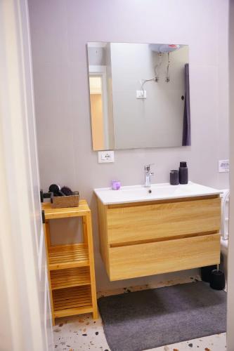 une salle de bain avec un lavabo en bois et un miroir dans l'établissement Cherry Rooms, à Tirana