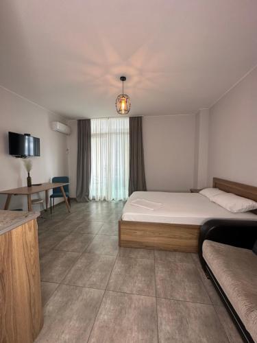 a bedroom with a bed and a desk and a table at Aqua Batumi 39 in Batumi